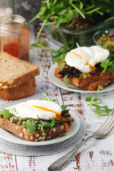 Homemade sandwiches with pesto, green salad and poached eggs