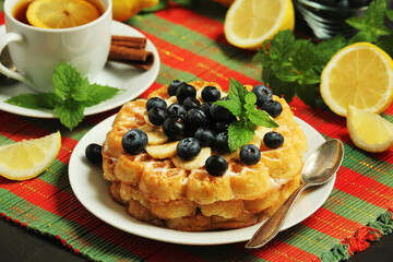 Belgian waffles with blueberry and a cup of tea with lemon