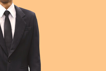 Business man black suit with orange pastel color background.