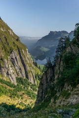 The Alpstein mountain range in Appenzell, Switzerland with the fog in the valley  and the view of the Seealpsee lake