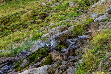 A small creek spraying water when rushing down from a mountain