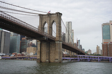 Obraz premium Looking up at the Brooklyn Bridge on the river