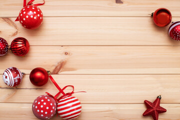 Christmas card. Red Christmas balloons are scattered on a light wooden background. Flat bed, top view, copy space. Christmas frame, new year's banner layout