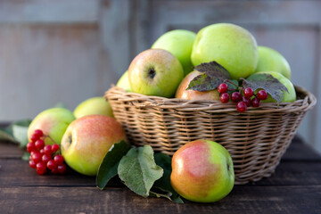 Healthy organic apples in a basket on a wooden background in the sunlight. The concept of a healthy diet.