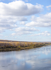 Beautiful, wide river autumn among the woods.