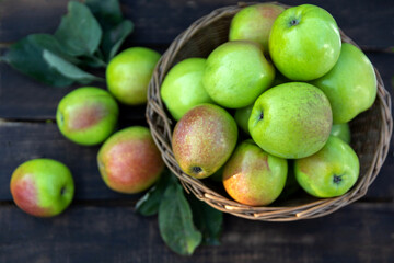 Naklejka na ściany i meble Healthy organic apples in a basket on a wooden background. Autumn harvest.