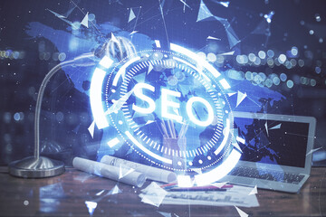 Multi exposure of table with computer and seo drawing hologram. Search optimization concept.