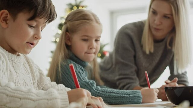 Video of children focused on writing letter to Santa Claus. Shot with RED helium camera in 8K.