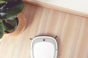 Fototapeta na wymiar Vacuum cleaner robot perform automatic cleaning the floor.
