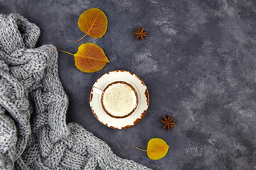 Obraz na płótnie Canvas Autumn composition. Cup of coffee with milk, autumn leaves and plaid on grey background. Flat lay, top view.