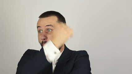 A young successful businessman funny portrays a karate, punches the air with his hands. Portrait of a young successful businessman he funny portrays a fight imitating karate. - Powered by Adobe