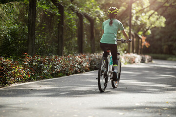 Woman riding on bike path at park on sunny day