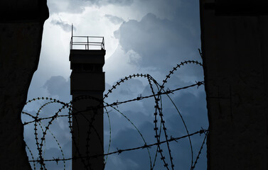 watchtower behind a wall with barbed wire as a symbol of division