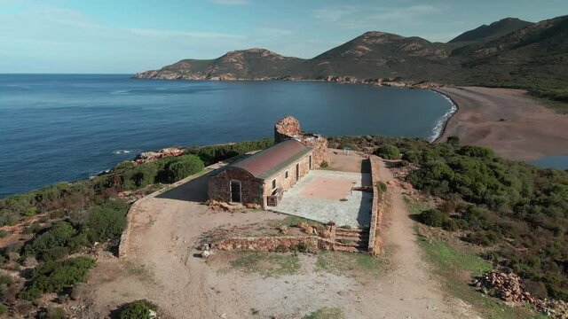 Aerial view of the 16th century Genoise tower overlooking Gal&eacute;ria beach and the Mediterranean sea in Corsica under a clear blue sky