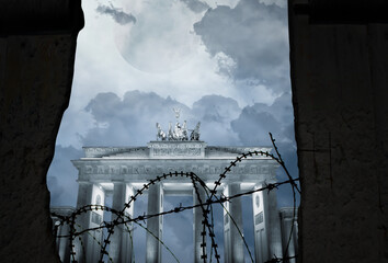 Brandenburg gate behind a wall with barbed wire as a symbol of division