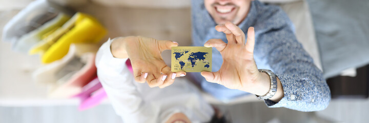 Man and woman are smiling and holding a bank card. Plastic cards for purchases concept