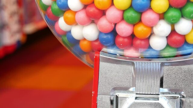 Colorful gumballs in classic vending machine, USA. Multi colored buble gums, coin operated retro dispenser. Chewing gum candies as symbol of childhood and summertime. Mixed sweets in vintage automate.