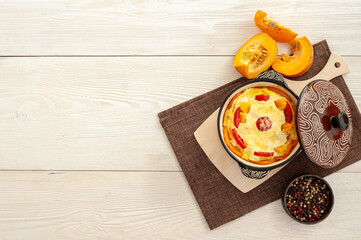 Autumn cooking. Pumpkin casserole on a white wooden background. A place for text.