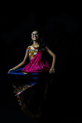 Indian girl in traditional chaniya choli for navratri with a fashionable hairstyle poses in studio...