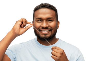 health care, hygiene and people concept - smiling african american young man with dental floss...