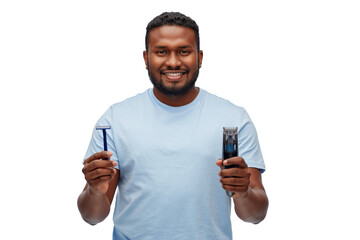 shaving, grooming and people concept - smiling young african american man choosing between manual razor blade and trimmer over white background