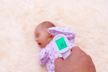 Measuring the temperature of a newborn baby using an infrared thermometer