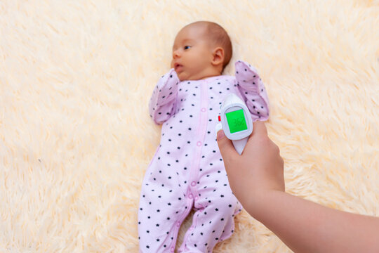 Measuring The Temperature Of A Newborn Baby Using An Infrared Thermometer