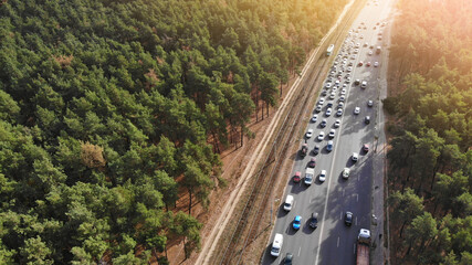 Aerial. Traffic on a highway between forest. Peak hour. View above from drone.