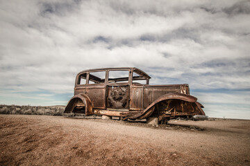 Fototapeta na wymiar Abandoned Car in the American southwest desert at the Petrified Forest Painted Desert National Park. 