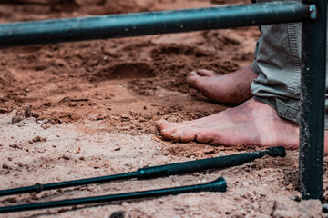 Fungus Infection on Nails. Bare foot close up, cowboy performing at rodeo show, sunset, brown sand, natural daylight.
