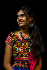Indian girl in traditional chaniya choli for navratri with a fashionable hairstyle poses in studio...