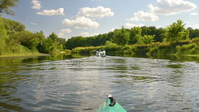 Canoe floats on calm river in summer green forest. Isolation, relaxation, family holiday, healthy lifestyle concept