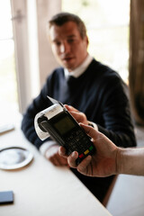 Businessman paying the bill with a credit card in restaurant.