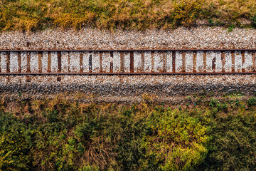 Old railroad track through countryside in autumn, aerial view