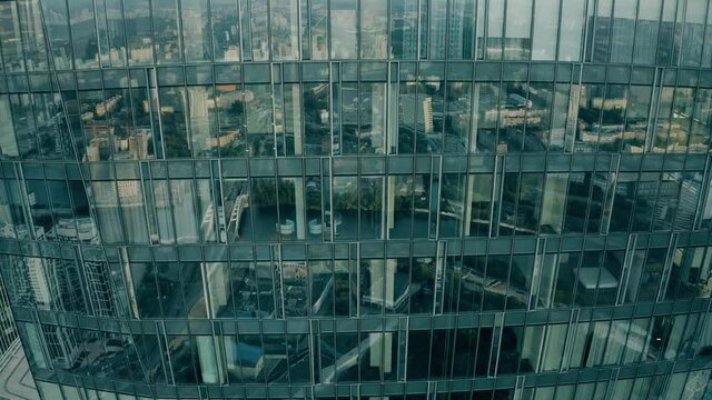 Aerial view of panoramic windows of a skyscraper reflecting big city