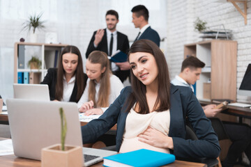 Young pregnant girl works with a young team.