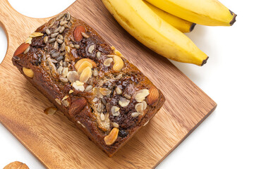 Banana bread on wooden plate with banana isolated on white background.