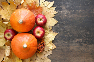 Autumn background with pumpkins, dry leaves, apples, walnuts, chestnuts and pine cones