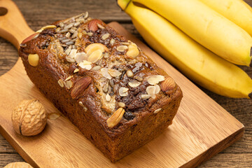 Close up Banana cakes are placed on a wooden tray on a wooden table, with bananas as background.