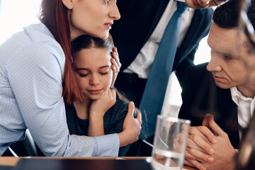  Man in suit tries to calm mother and daughter.