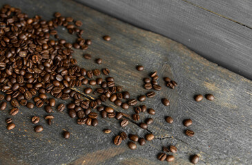Roasted arabica coffee beans scattered on a wooden table. Fresh coffee beans.
