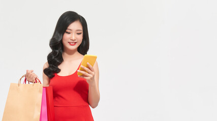 Portrait Asian beautiful happy young woman smiling cheerful and holding credit card and using smart phone for shopping online with shopping bags