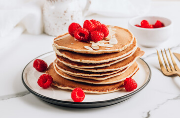 Homemade classic american pancakes with almond, fresh raspberries.