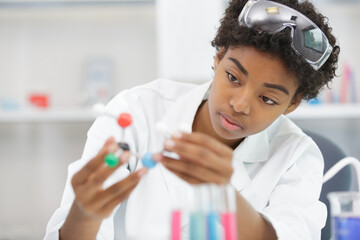 woman lab assistant looks at dna model