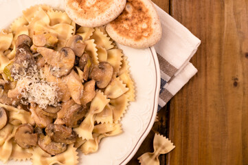 A plate of pasta with mushrooms and tijelle. Butterfly pasta with mushrooms and parmesan cheese sauce. Typical italian cuisine from the south of italy. Copy space. Above