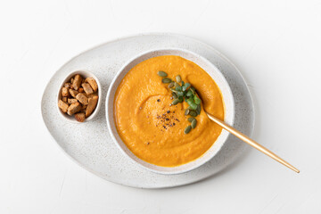 Fall pumpkin soup with crackers on white background. Top view. Space for text.
