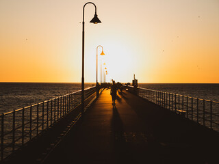Sunset at the beach - Families Strolling On The Jetty At Sunset.