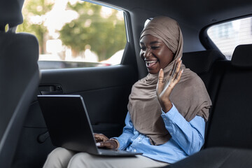 Online Business Meeting. Muslim businesswoman making video call with laptop in car