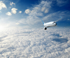 Fototapeta na wymiar Landscape with airplane is flying in the blue sky and white clouds.