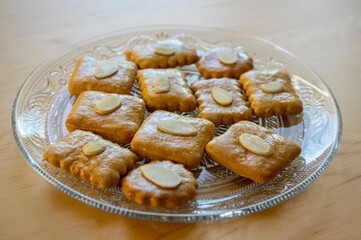 Group of delicious sweet Christmas honey gingerbread cookies on wooden table on trasparent glass plate, various shapes